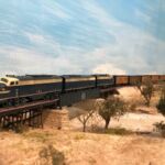 This photo shows one of Bill Van der Meer's F unit sets crossing a through girder, ballasted deck bridge over the Brazos River on his Sweetwater & Orient #2. Bill Van der Meer photo. ATSF F units cross the Brazos River (model)