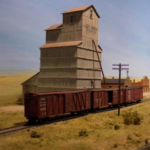 Tis model of an AMB grain elevator features an extended dump shed, external beams, and numerous NBW casting and individual sheets of corrugated siding. It is on Bill Van der Meer's Sweetwater & Orient (#1). Mdel of grain elevator